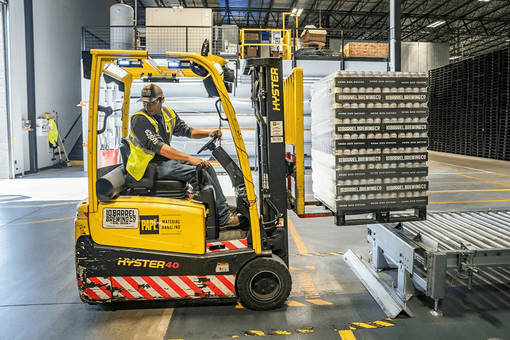 Warehouse worker operating a forklift to move inventory, representing Mocean SMS messaging campaign for operations and logistics updates.